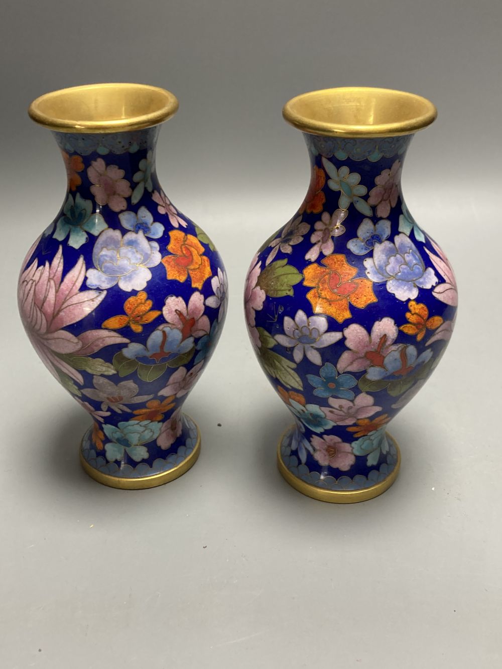 A group of Chinese wood stands and cloisonne enamel vases